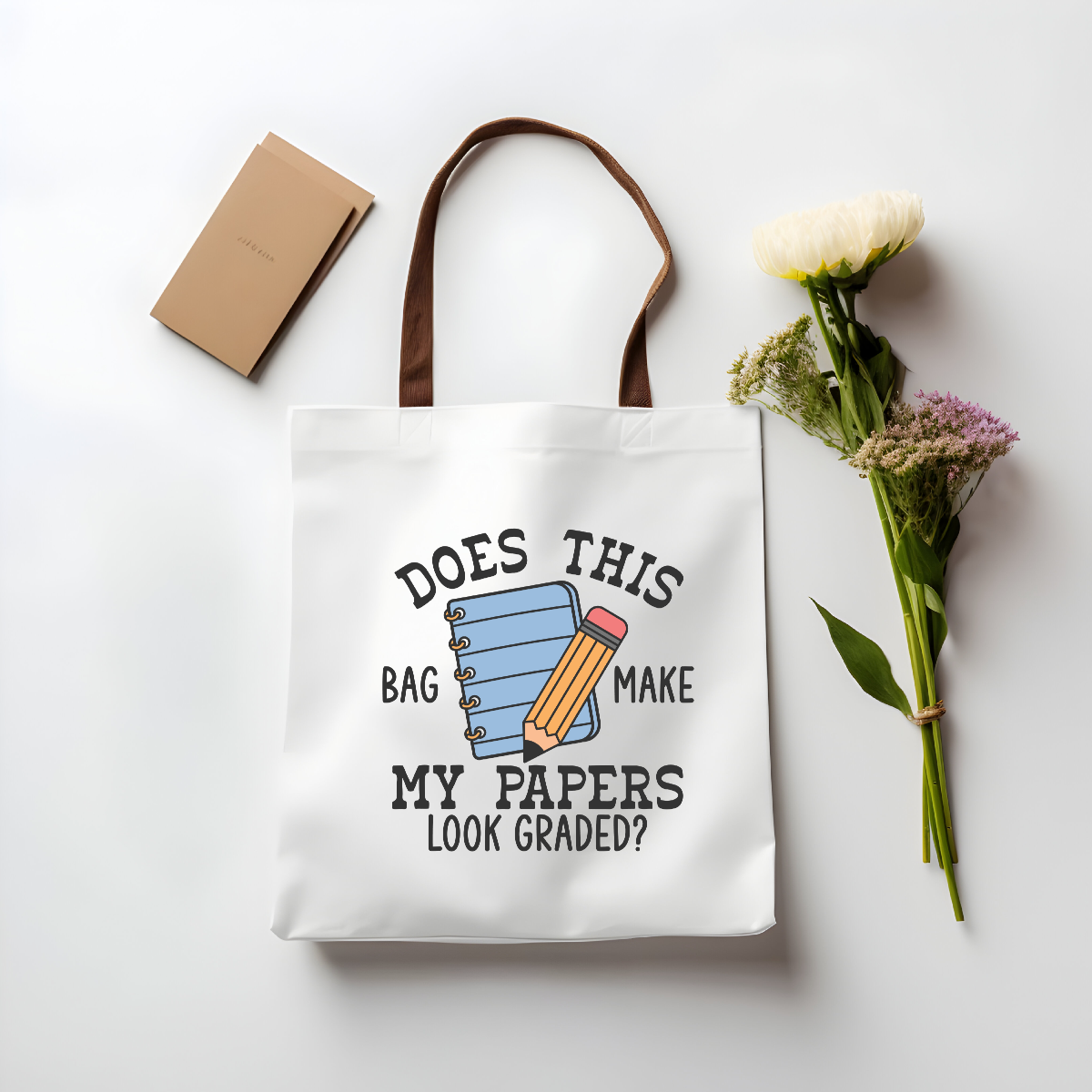 Teacher tote bag with brown handles – displayed with flowers