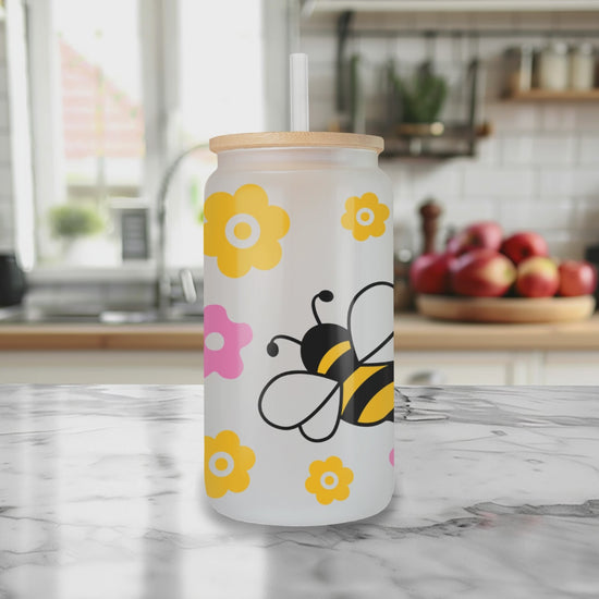 Rotating view of Bee Kind glass can tumbler with bamboo lid and straw
